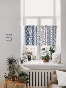 Detail of bohemian blue and white geometric floral pattern on cotton linen cafe curtain
