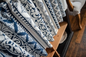 Macro detail of blue floral pattern on thick linen fabric with premium drape and texture