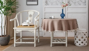 Close-up of brown textured tablecloth featuring geometric patterns and white cotton tassels