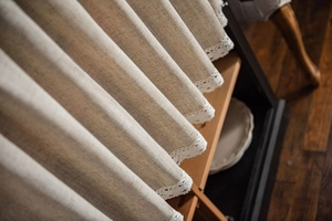 Detail eines Vorhangs aus beigem Leinen mit eleganter weißer Häkelspitzenkante