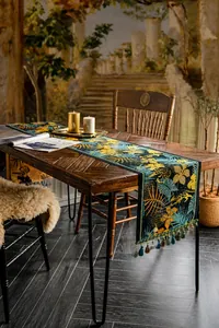 Dettaglio di runner da tavola vintage con motivi tropicali, leopardo e nappine colorate