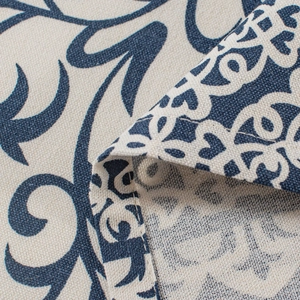 Detailed close-up of navy blue floral pattern on thick beige cotton linen fabric