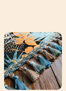 Dettaglio del runner da tavola boho con motivo jacquard vegetale e nappe fatte a mano