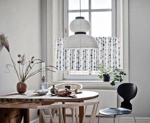 Blue striped coffee curtain with tassels shown in a bright modern kitchen window setting