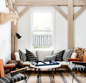 Detail view of blue striped curtain with elegant beige tassels in a cozy home setting