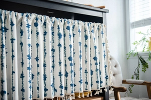 Detail of blue striped linen curtain with elegant beige tassels for cabinets