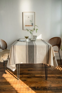 Detail of striped linen tablecloth in beige and brown for a rectangular dining table