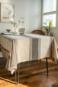 Close-up of thick beige linen tablecloth featuring charcoal grey stripe pattern details
