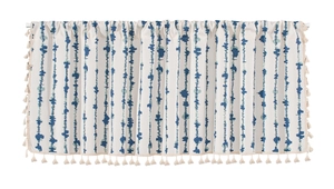 Detail of blue striped window valance with bohemian tassels and cotton linen texture