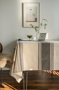 Detail of striped linen tablecloth showing natural sunlight and blind shadows
