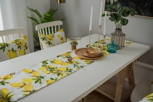 Macro detail of yellow lemon print fabric showing textures on table runner and cushion