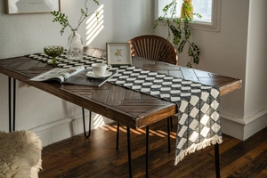 Detail of black and white geometric diamond woven table runner with decorative tassels