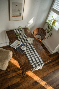 Close-up detail of black and white checkered table runner with delicate fringe tassels