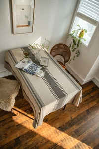 Detail of striped linen tablecloth with natural sunlight casting elegant shadows on texture