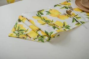 Detail of yellow lemon and green leaf pattern on a double-layer table runner fabric