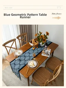 Dettaglio runner da tavola blu con motivi geometrici e nappe su tavolo in legno scuro