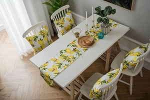 Detail showing lemon print table runner and matching cushion cover in a rustic setting