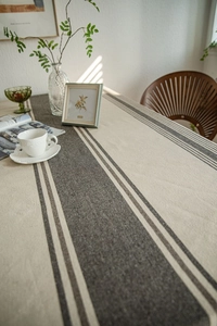 Close-up of linen-textured tablecloth with elegant brown striped borders and natural finish