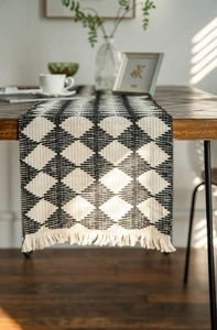 Detail of black and white diamond pattern table runner with hand-woven cotton tassels