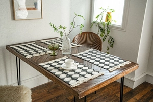 Detail view of cotton woven table runner featuring black and white diamond pattern and tassels