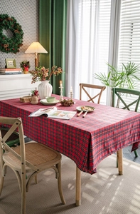 Detailed view of red plaid tablecloth with classic tartan patterns in a warm dining setting