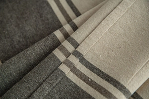 Macro detail of high-quality striped linen fabric showing texture and soft drape