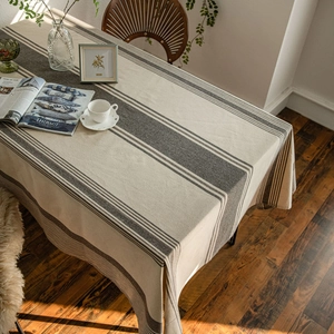 Japanese style striped linen tablecloth in beige and dark gray on a wooden table