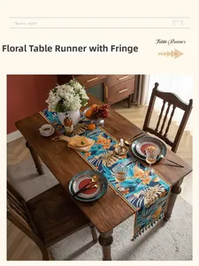 Dettaglio del runner da tavolo tropicale con stampe di frangipani e nappe a frangia