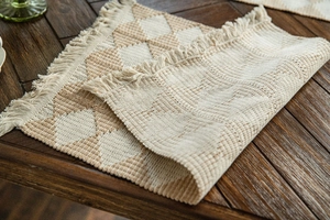 Detailed macro view of bohemian woven cotton table runner with geometric diamond patterns