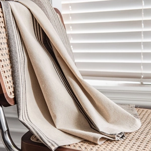 Striped cotton linen curtain hanging on a wooden chair by window with blinds