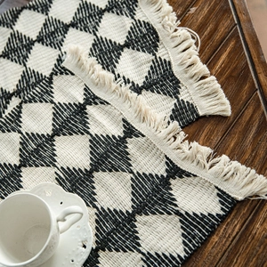 Cotton woven table runner with black and white diamond pattern and tassel trim