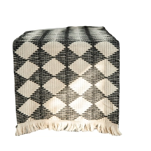 Cotton woven table runner with black and white diamond patterns and tassel edges