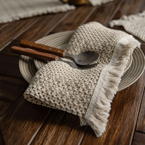 Runner da tavola beige intrecciato a righe traforate con nappe su legno