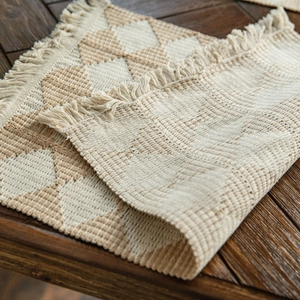 Bohemian style cotton woven table runner with geometric triangle pattern and tassel trim