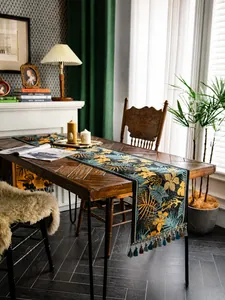 Dettaglio del runner da tavolo con stampa leopardata tropicale e nappe blu decorative