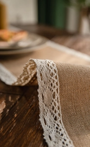 Detailed macro view of natural jute fabric with delicate white lace edging trim