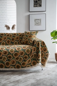 Detail of sunflower jacquard sofa cover with cream tassels in a cozy home setting