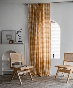 Detail of yellow and white plaid cotton linen curtain with decorative fringe edge