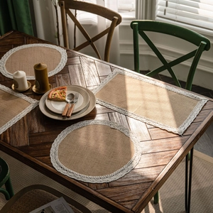 Natural jute table runner with white lace edges on a rustic wooden dining table