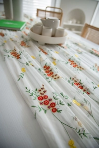 Detail van bloemenborduurwerk op een halftransparant wit tafelkleed voor decoratie