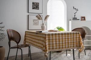 Close-up of yellow and black checkered tablecloth with delicate tassel fringe detailing