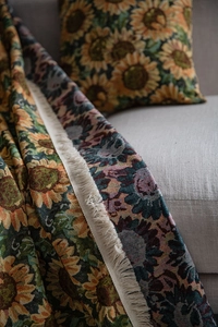 Detail of sunflower jacquard sofa throw with vintage floral patterns and fringe edges