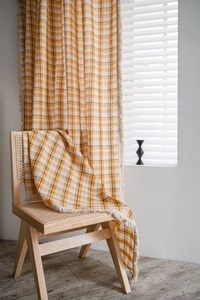 Detailed texture of yellow plaid curtain fabric with delicate short fringe edges