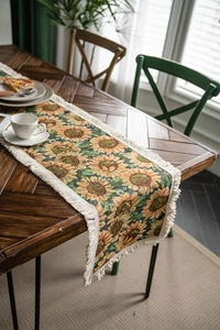Detail of sunflower jacquard pattern and white fringe tassels on thick table runner