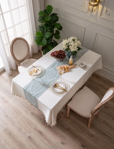 Detail of French country style tablecloth with sage green floral runner and elegant tassels