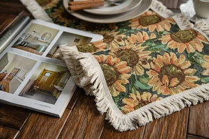 Detailed close-up of sunflower jacquard weave pattern with white cotton tassel edge