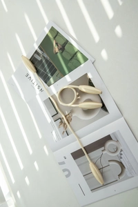 Détail d'embrasse de rideau magnétique or champagne avec corde tressée sur un magazine de mode