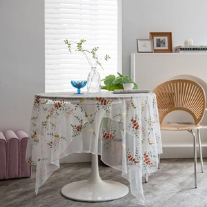 Elegant wit kanten tafelkleed met bloemenborduursel op een ronde tafel bij zacht licht