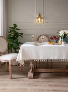 Close-up of ivory rectangular tablecloth with thick woven fabric and elegant fringe tassels