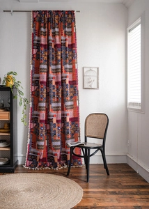 Detail view of Bohemian printed curtain with vibrant patterns and white tassel fringe